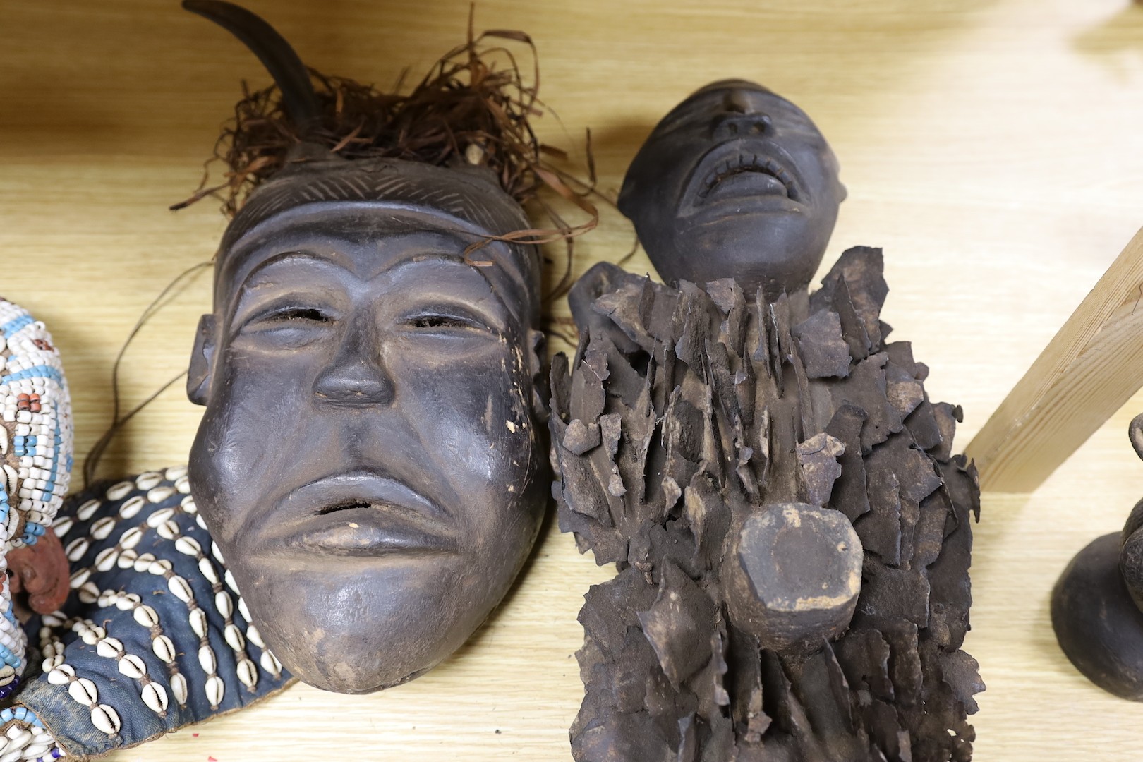 A group of Democratic Republic of Congo tribal carved wood figures and instrument and a Kuba style beadwork and shell mount mask